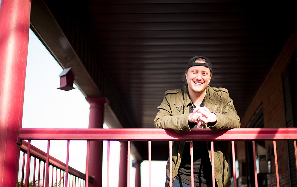 A photo of AJ leaning on a railing.