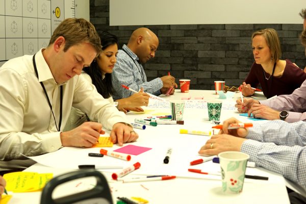 A photo of people working around a meeting table.