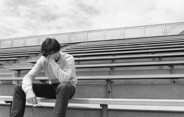 Depressed teen in bleachers